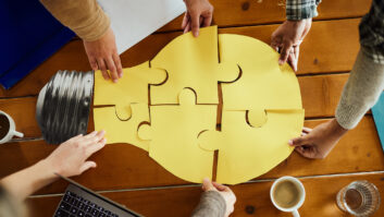 A team works together to build a light-bulb puzzle to show cooperation.