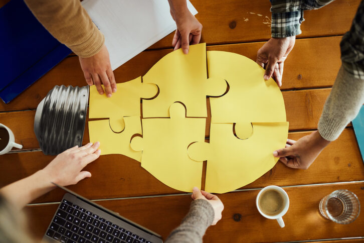 A team works together to build a light-bulb puzzle to show cooperation.