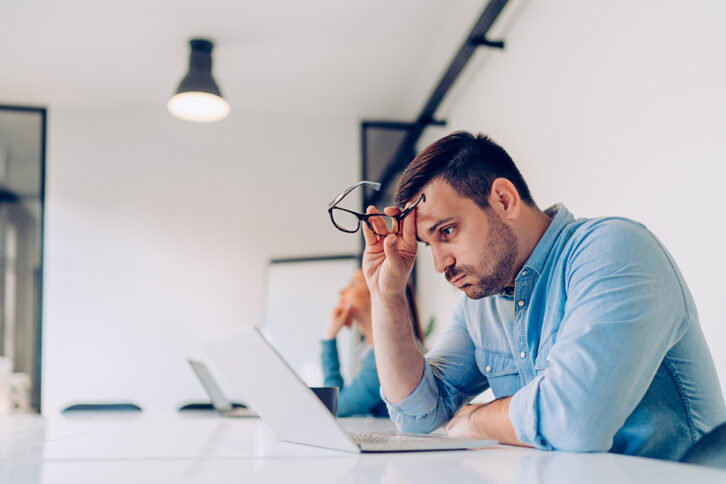 Frustrated person looking at his laptop